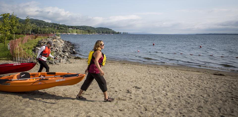 two woman pull their kayaks as they get ready to enjoy the beautiful lake.