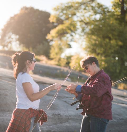 Two women set up fishing lures on the shores of Lake Champlain.