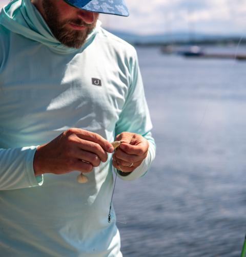 A man prepares a fishing rod with bait.