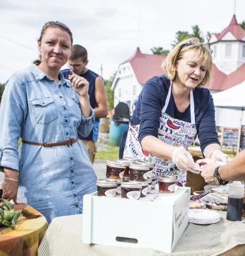 Two women sell their jams to patrons.