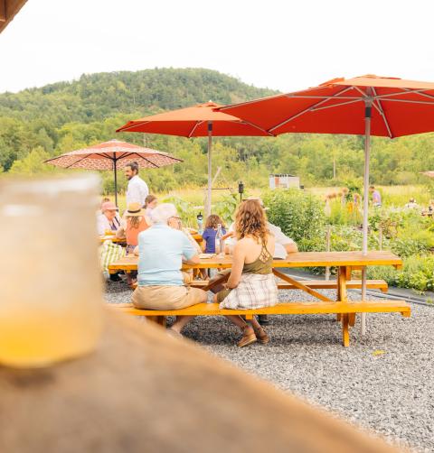 Echo Farm outside patio and dining area with drinks and people eating at patio tables.