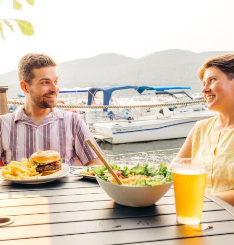 Two people eating a meal on a patio during the summer.