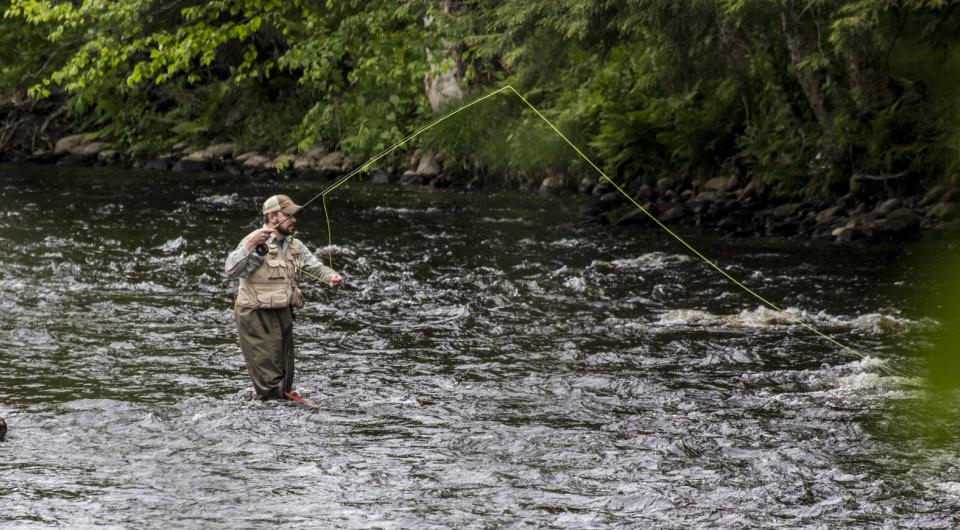 A fly fisherman casting in the water