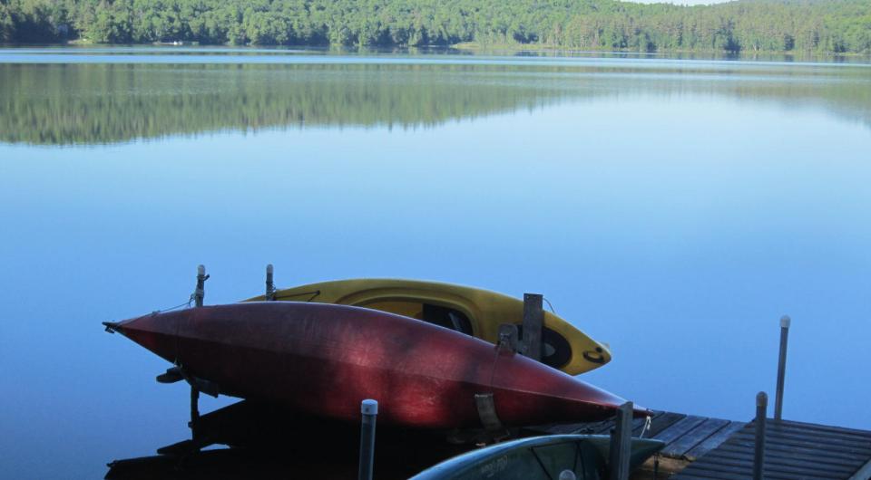 A dock with some kayaks on a pond