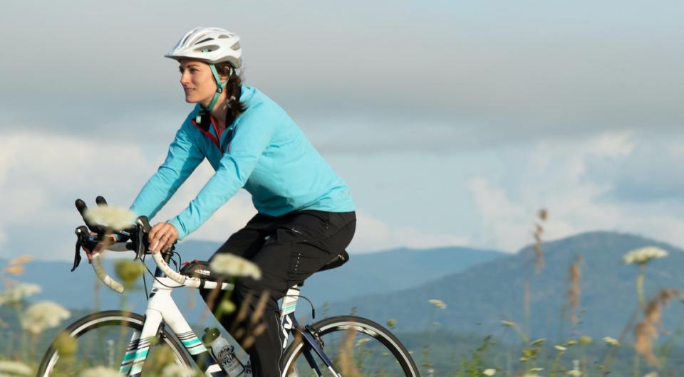 A cyclist riding with mountains in the background