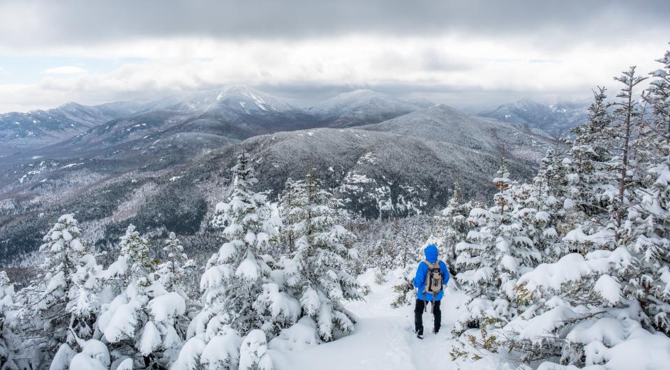 A snowshoer looking out at snow-covered mountain