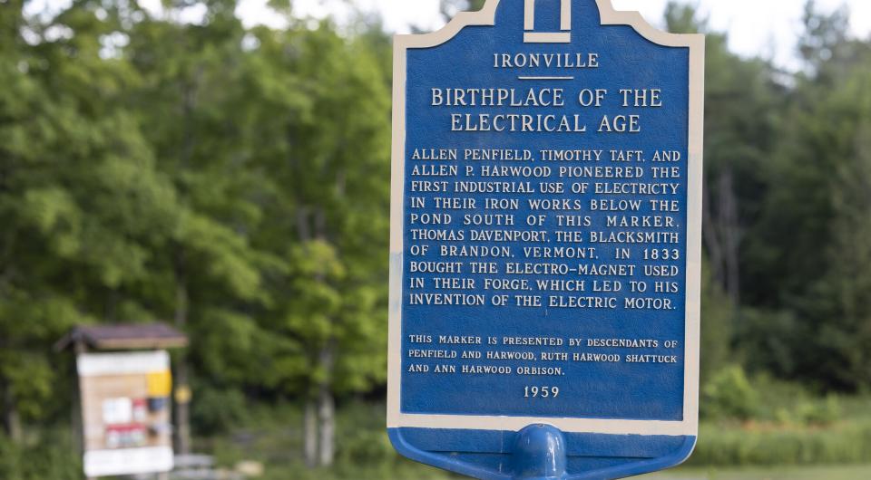 A blue metal sign for the Birth of the Electrical Age in Ironville