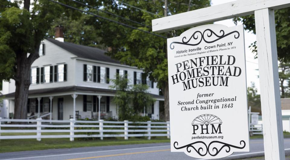 A white wooden sign for the Penfield History Museum.