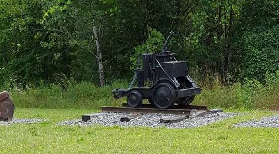 An old mine cart on display outdoors.