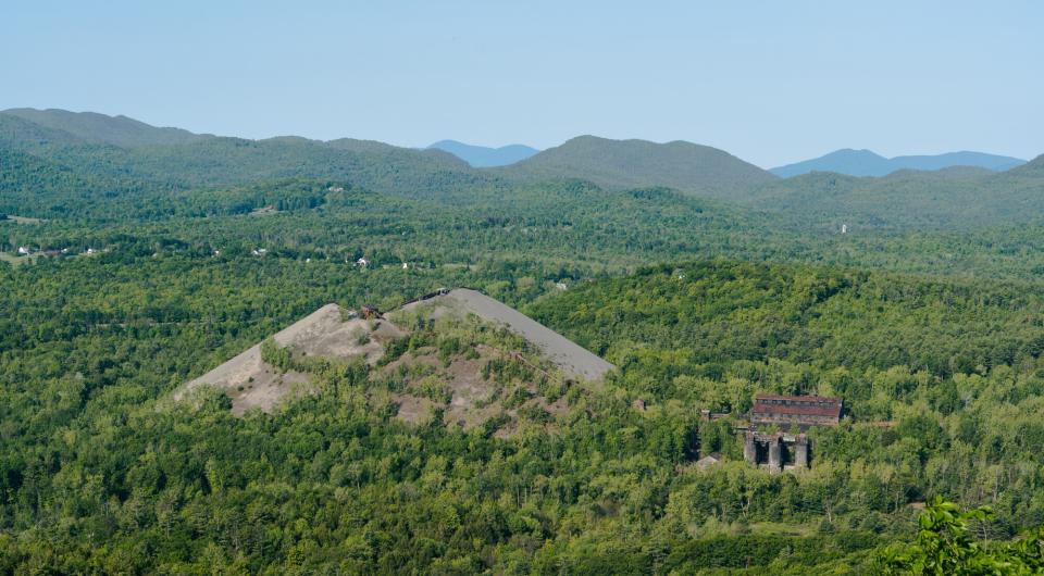 A large pile of mine tailings seen from a mountain