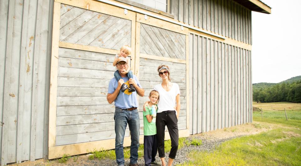 A family in front of a farm building