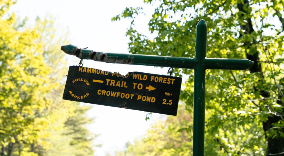 A wooden sign for Crowfoot Pond