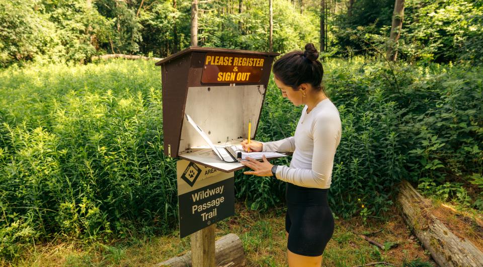 A hiker registering in a logbook