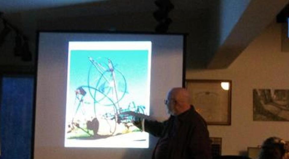 A man giving a presentation on sculptures