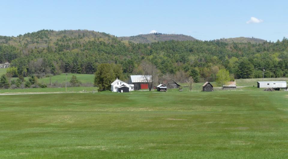 An open field with a farm in the middle. 