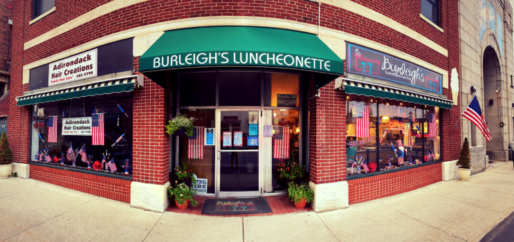 The exterior of a brick-fronted restaurant with a green awning.