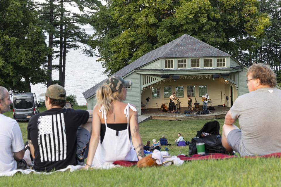 people sitting on the lawn enjoying live music