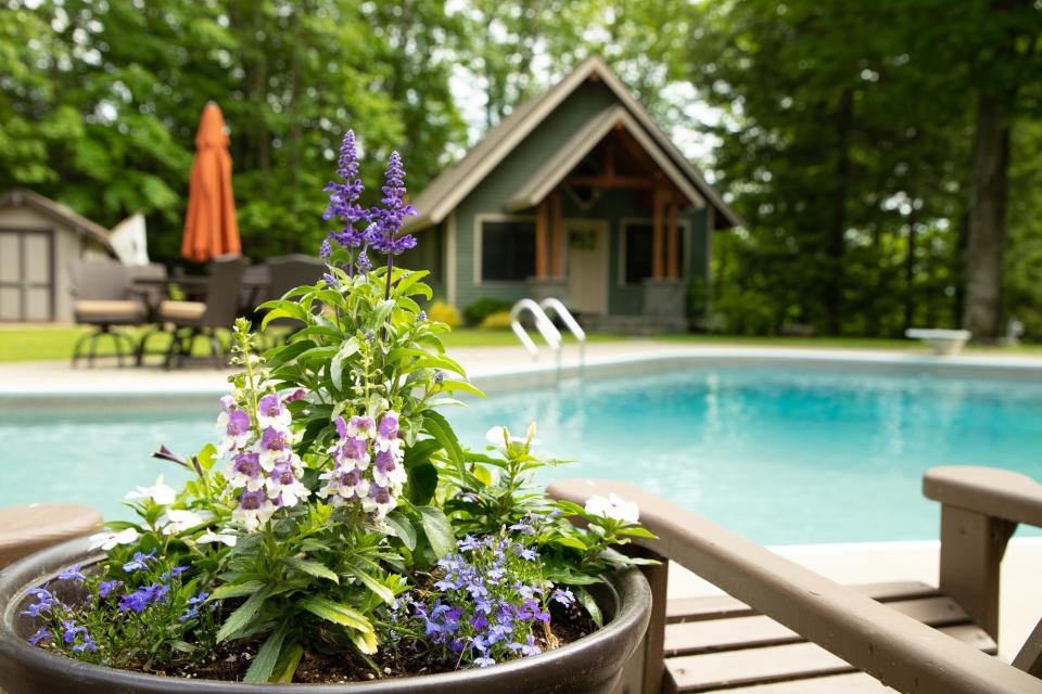 A pool next to a cottage.