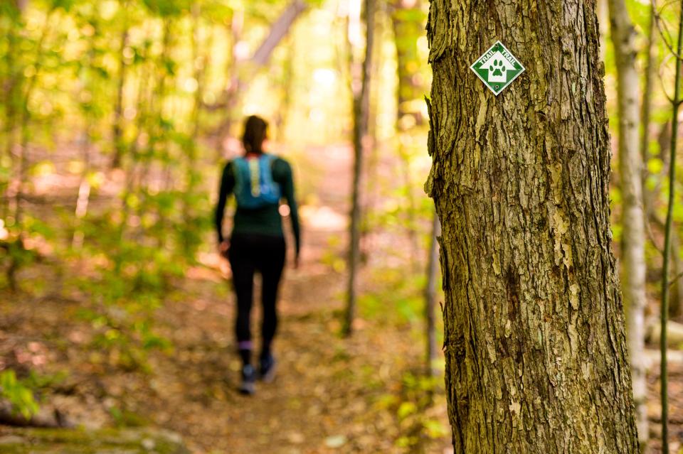 A women with a running pack walking down CATS trail