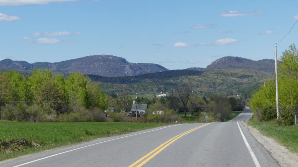 A road through a lush farmscape.