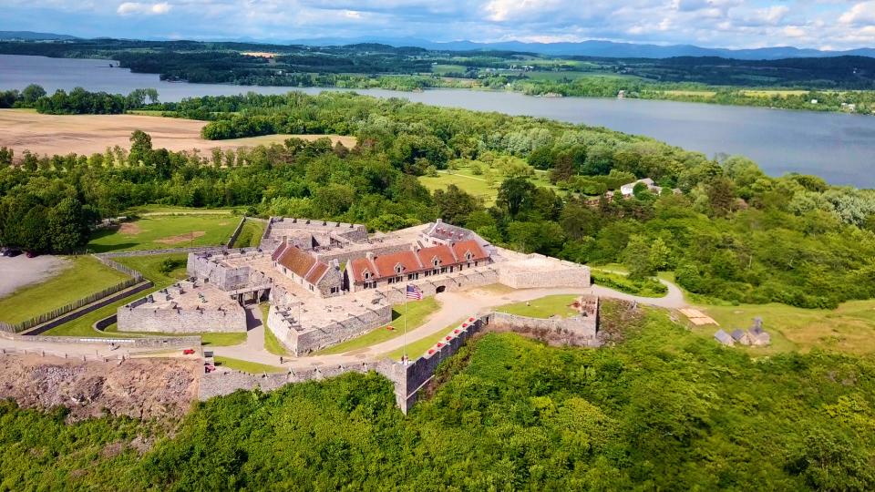 ​​​​​​​​An aerial view of Fort Ticonderoga with Lake Champlain and mountain ranges in the background.