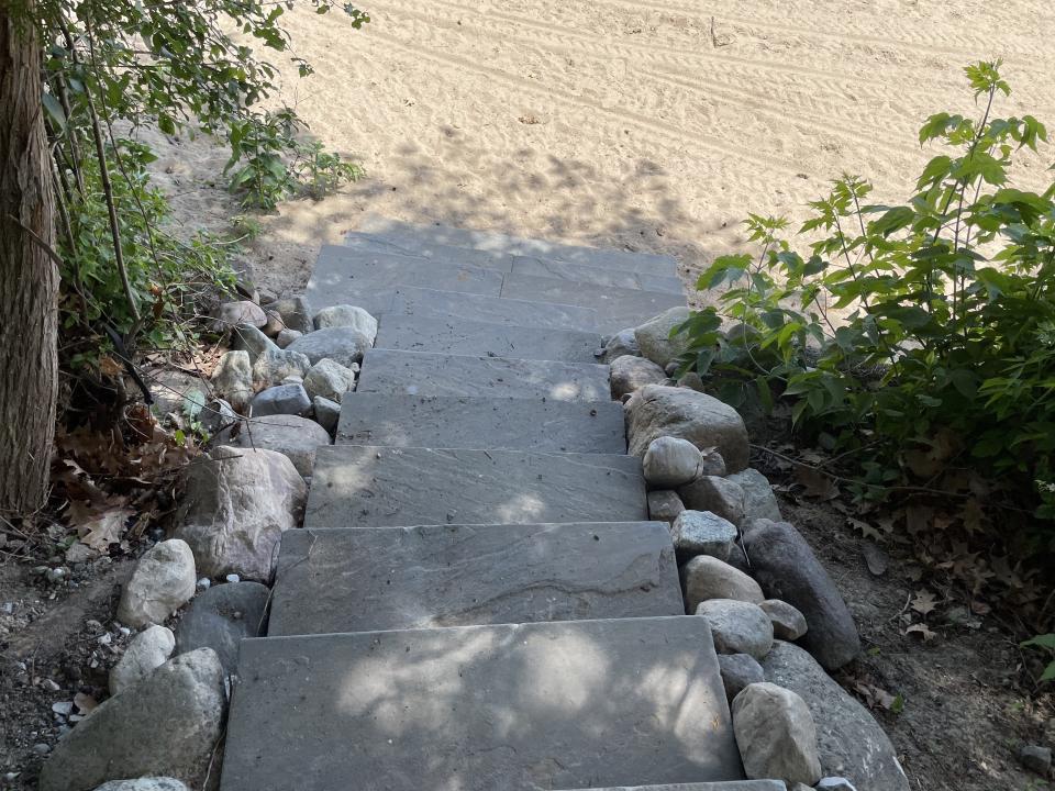 A blue stone staircase leading to a beach.