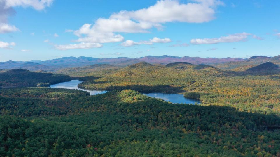 A view from a mountain with a distant hills and a body of water