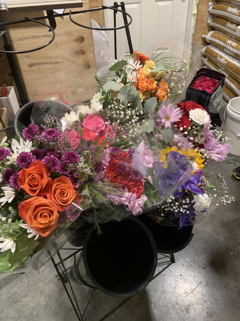 Floral arrangements wrapped in cellophane rest in a display