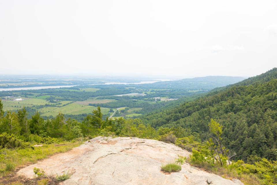 A rocky clearing atop a mountain overlooking a lake