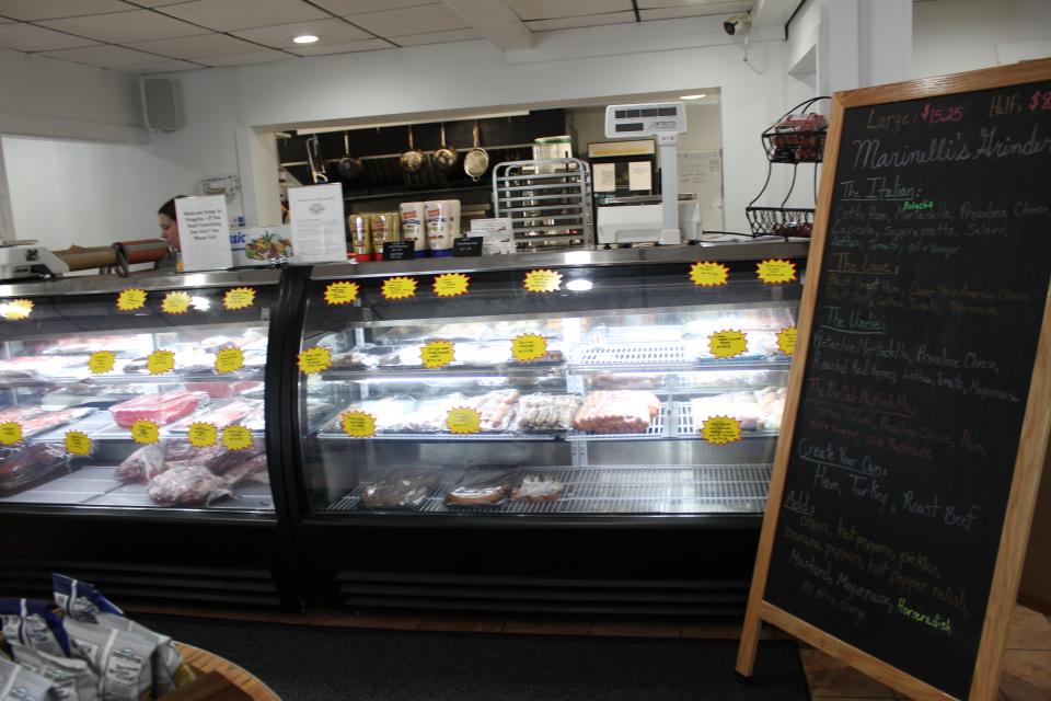 A refrigerator display case of meats and cheeses.