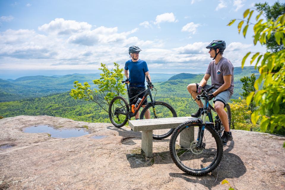 Two men atop blueberry hill in Elizabethtown on their bike