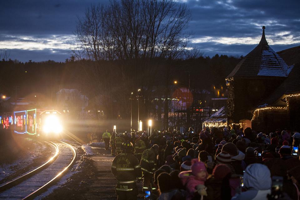 A train rolls into a snowy train station.