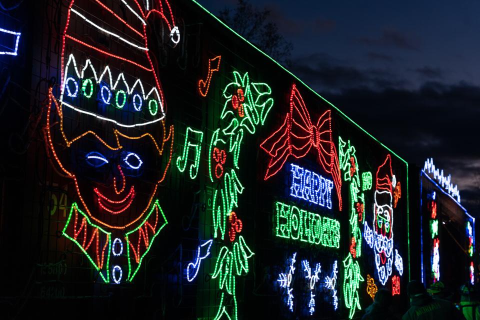 The side of a holiday train car with lights and characters.