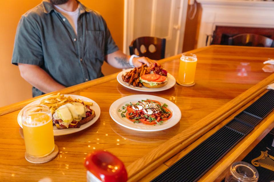 A wooden counter top with some plates of food at Mountain Dog Restaurant