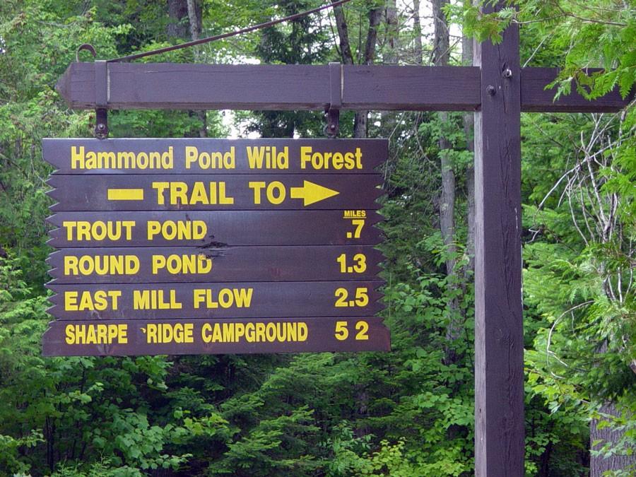 The trail sign is a reminder to sign in and out at the register.