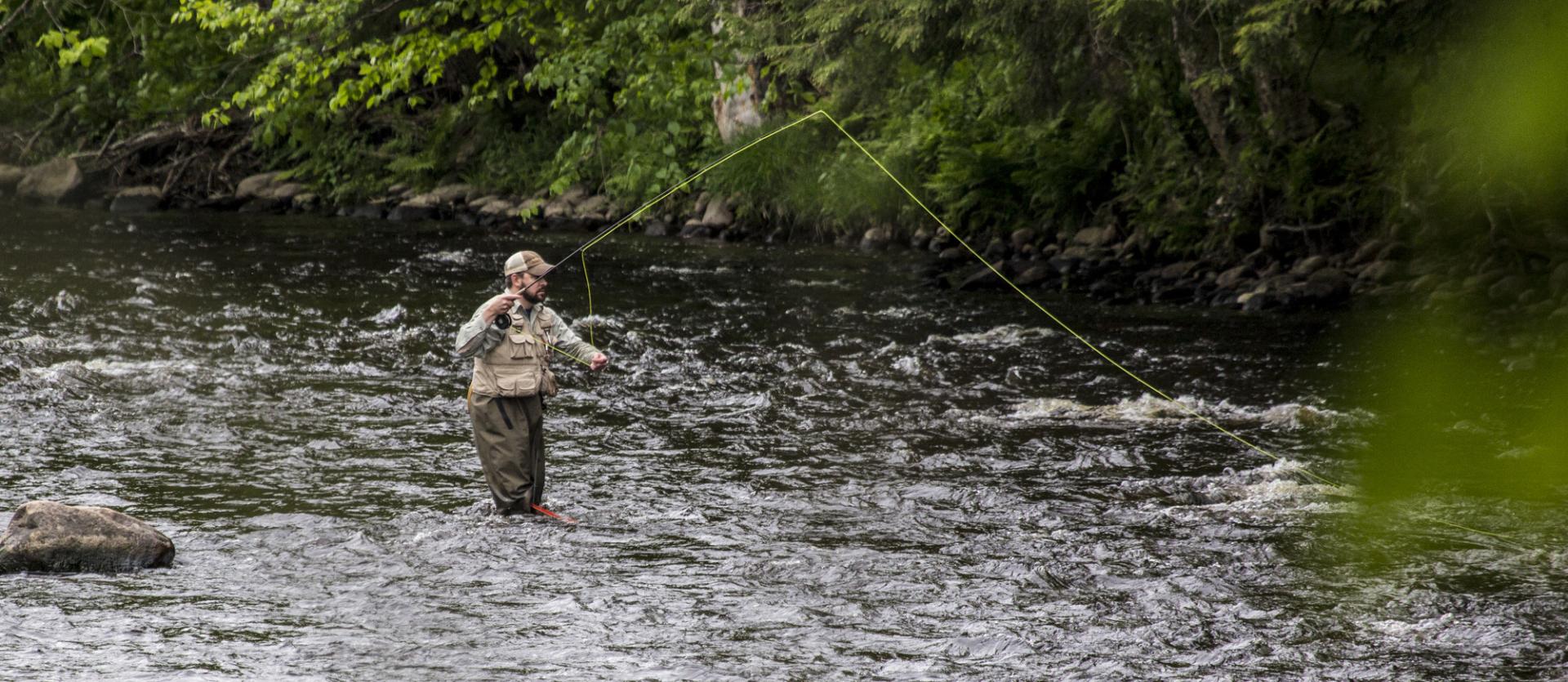 A fly fisherman casting in the water