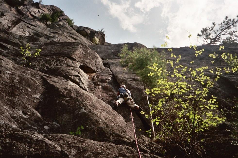 A climber goes up a rock route