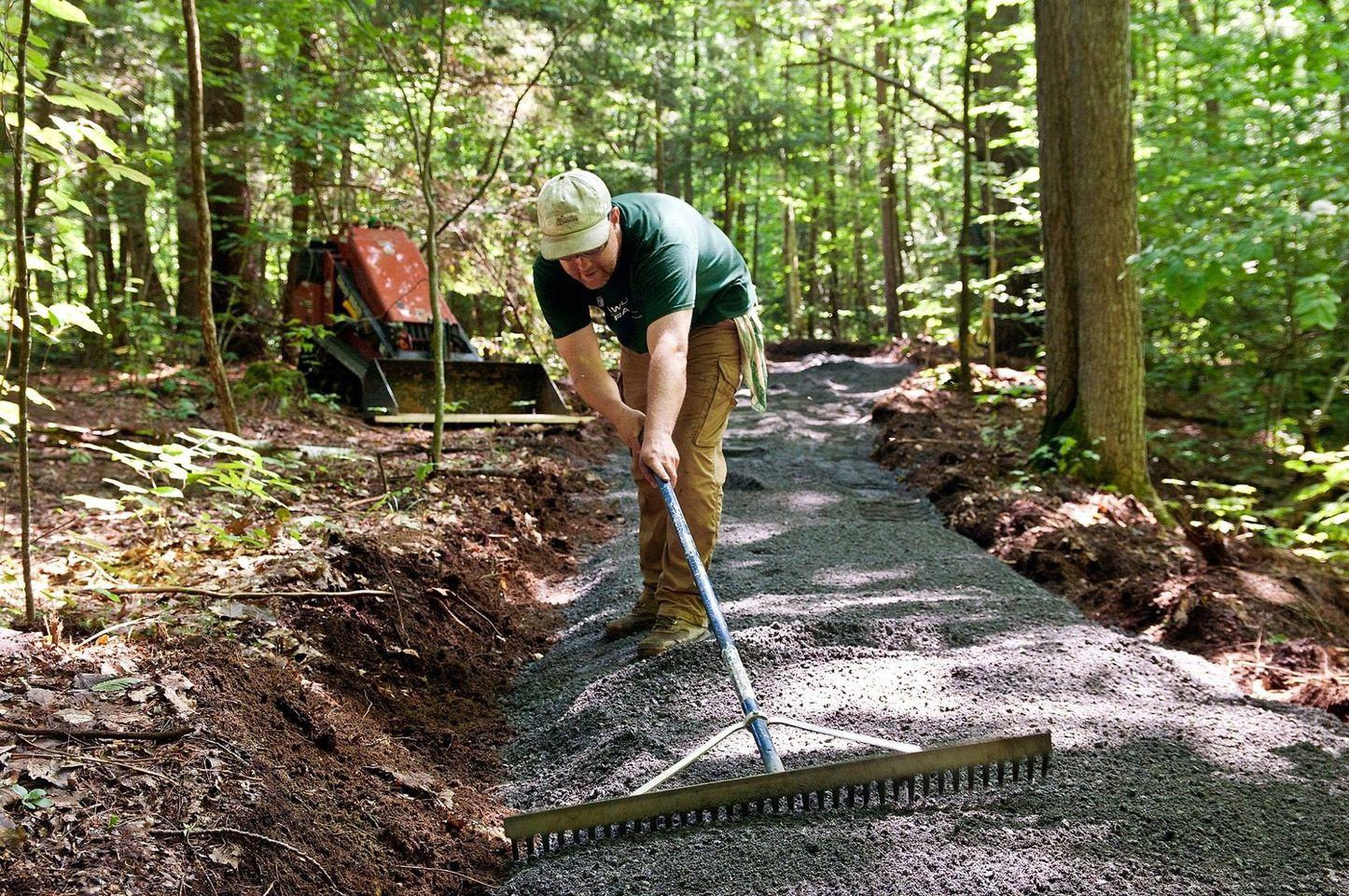 Someone spreading gravel for a new trail